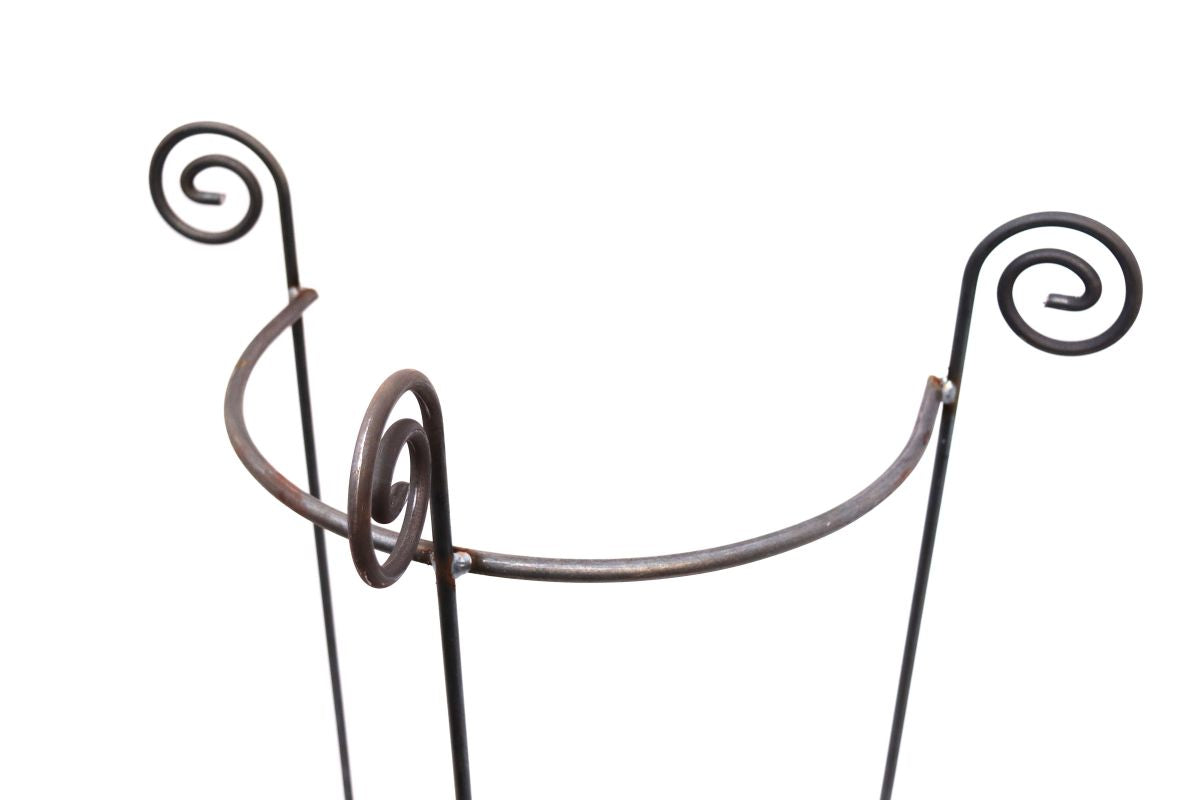 Eine Nahaufnahme des Hirsch Staudenhalters / Rankhilfe HUGO, halbrund, 90 cm hoch, mit drei Beinen und dekorativen Spiralmotiven am oberen Ende, 45 cm breit – ideal zur Präsentation neben einem Schrank – vor weißem Hintergrund.