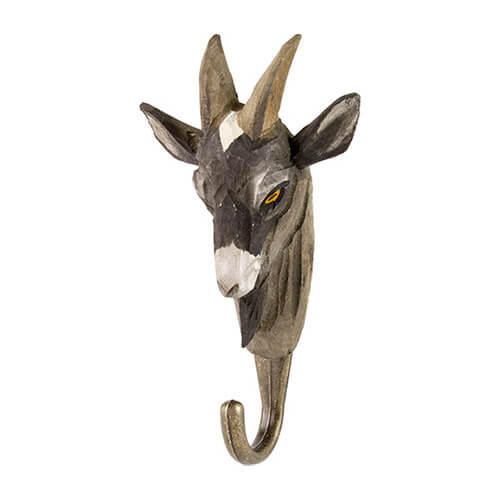 Der Wildlife Garden Handgeschnitzter Wandhaken aus Lindenholz 'Ziege' hat einen geschnitzten Ziegenkopf aus Holz mit zwei Hörnern, spitzen Ohren, einem gebogenen Metallhaken, grauen, weißen und schwarzen Details sowie einem auffälligen gelben Auge.