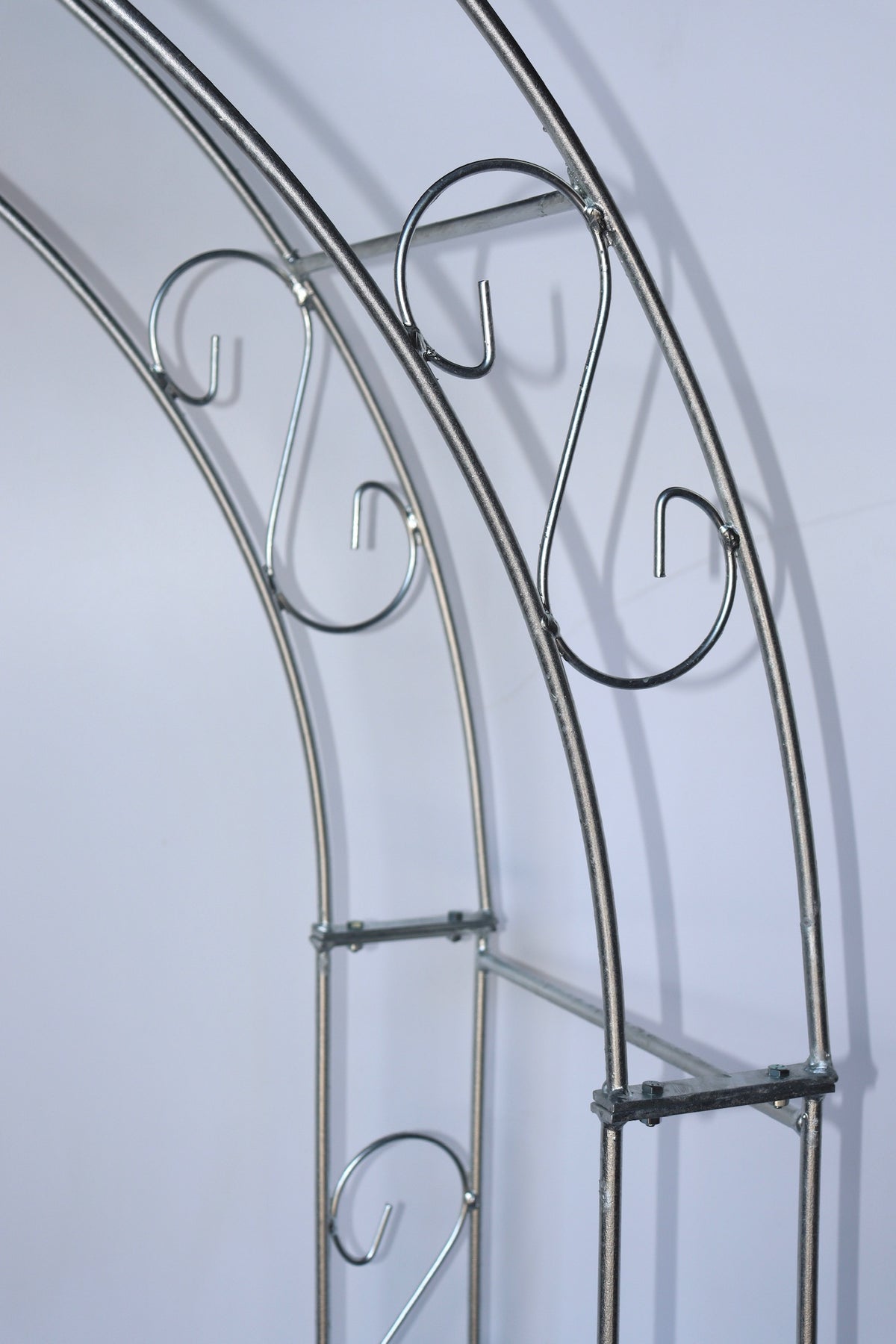Nahaufnahme des Rosenbogens SPITZ Vollmetall stabil, Vollmaterial 12 mm von Königliche Gartenakademie. Dieser feuerverzinkte Metallbogen mit glatten, glänzenden Stäben und filigranen Spiraldetails ist ideal als dekoratives Rankgitter oder Rosenbogen.