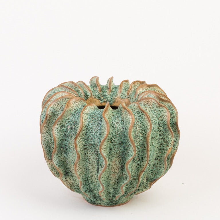 Die Des Pots Vase 'Moos' Grün aus Steingut (H 25 Ø 28 cm) zeichnet sich durch ein rundes, handgeformtes grünes Design mit kaktusartig gerippter Oberfläche, gesprenkelter Glasur, dezenten braunen Rändern und einer unregelmäßigen Öffnung aus.