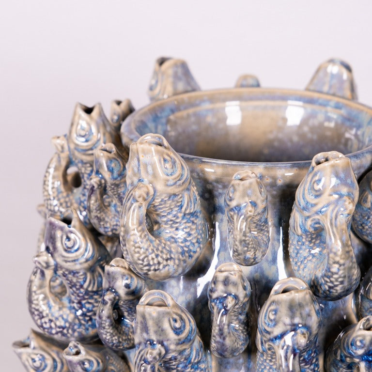 Nahaufnahme der Des Pots | Vase 'Fisch' Groß in blau aus Steingut (H 20 cm, Ø 30 cm), mit skulpturalen Fischen mit strukturierten Schuppen und offenen Mäulern, blau-beige glänzende Glasur, von Des Pots.