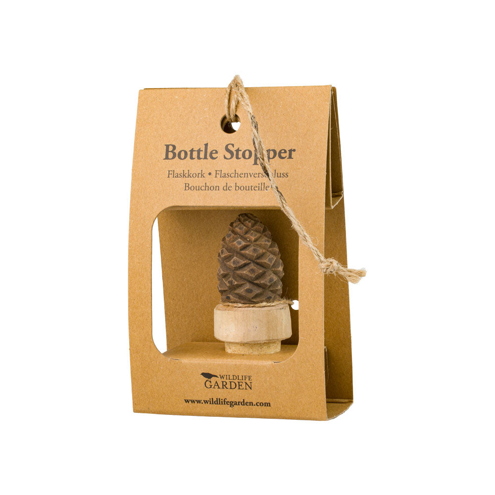 Der handgeschnitzte Flaschenverschluss aus Holz 'Tannenzapfen' von Wildlife Garden wird in umweltfreundlicher Kartonverpackung mit Kordelgriff präsentiert und trägt das Label Bottle Stopper sowie das Wildlife Garden Logo.