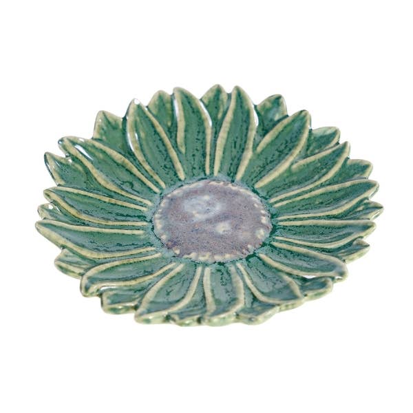 Eine „Grüne Schale“ von Werner Voß in Blumenform aus Steingut (15 x 15 x 2,5 cm), entworfen im unverwechselbaren Stil von Werner Voß, zeichnet sich durch grüne, blumenförmige Blütenblätter und eine dezent melierte, graue Mitte aus und wird hier aus einer schrägen Perspektive gezeigt.