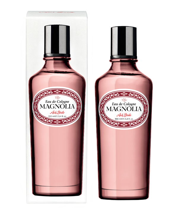 Zwei rosafarbene Glasflaschen von Ach.Brito Eau de Cologne | Magnolia 100 ml, beide mit weißem Etikett und schwarzem Verschluss - eine verpackt und eine unverpackt - werden vor einem schlichten weißen Hintergrund präsentiert.