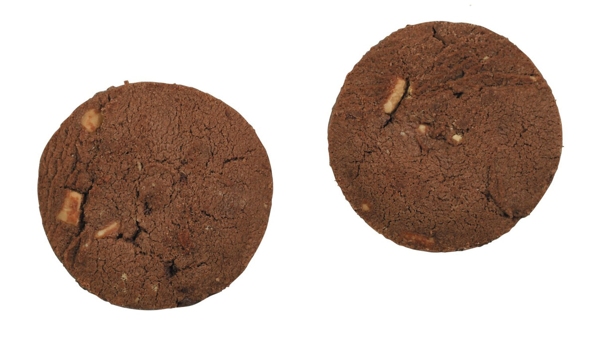 Zwei runde „Triple Chocolate Chunk“-Kekse von Cartwright & Butler | „Dreierleischokoladen“-Kekse von Lady Joseph mit kleinen Stückchen weißer Nüsse oder Schokoladenstückchen sind auf einem weißen Hintergrund abgebildet.
