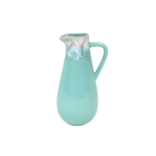 Der Costa Nova 'Taormina Aqua' Wasserkrug 1,65 l ist ein türkisfarbener Keramikkrug mit einem Henkel, einer glänzenden Oberfläche und einem weiß-rosa tropfglasierten Rand. Er wird in Portugal von Costa Nova handgefertigt und ist auf einem schlichten weißen Hintergrund abgebildet.