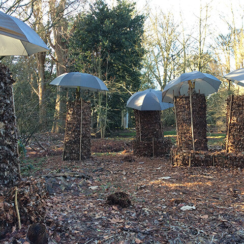 Hohe Stapel aus getrockneten Blättern und Zweigen mit Regenschirmen sorgen für ein kreatives Flair bei der Herbstvorbereitung, wie beim "RUNDGANG Was zu tun ist im Garten im Oktober" der Königlichen Gartenakademie, Mi. 07.10.2026, 15:00-16:30.