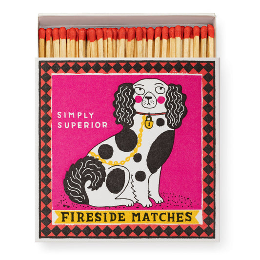 Die Archivist Gallery 'Staffordshire-Figur' Quadratische Streichhölzer Box zeigt rot gespitzte Streichhölzer und einen schicken Hund mit Goldkette auf rosa, beschriftet mit "SIMPLY SUPERIOR" und "FIRESIDE MATCHES" - ein stilvolles Geschenk für gemütliche Kaminabende.