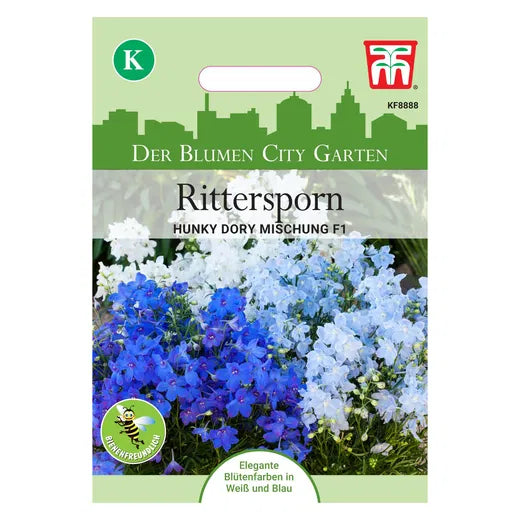 Eine Packung mit Samen von Thompson und Morgan Rittersporn 'Hunky Dory Mix' F1 (Delphinium grandiflorum) zeigt blaue und weiße Blüten auf einer grün-weißen Verpackung mit deutschem Text, einem Etikett "Hunky Dory Mix" und einem bienenfreundlichen Symbol.