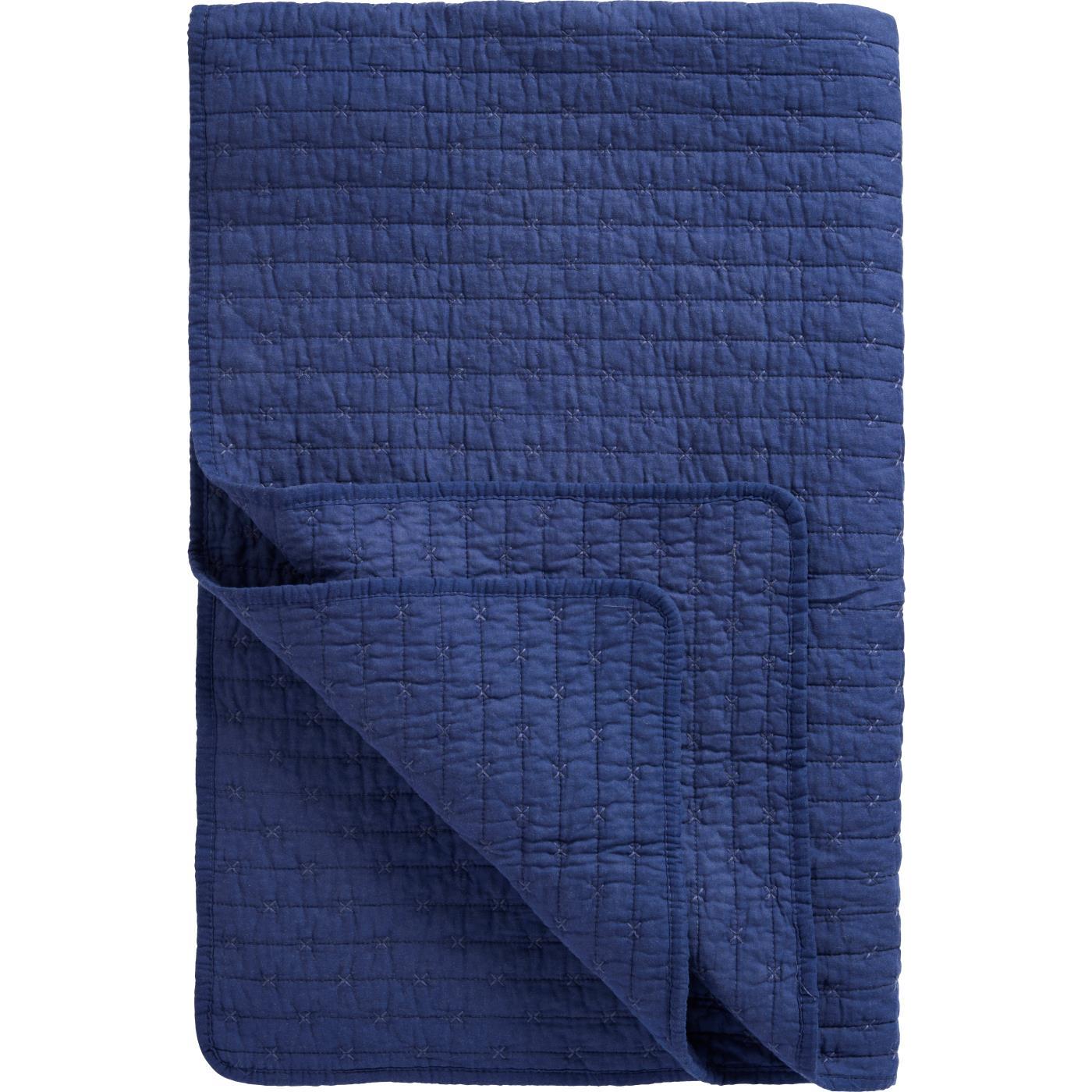 Eine ordentlich gefaltete Ib Laursen | Quilt Decke Indigo blau mit Kreuzstich von IB Laursen in marineblau zeigt eine umgedrehte Ecke, die die Unterseite und das Kreuzstich-Gittermuster zeigt.