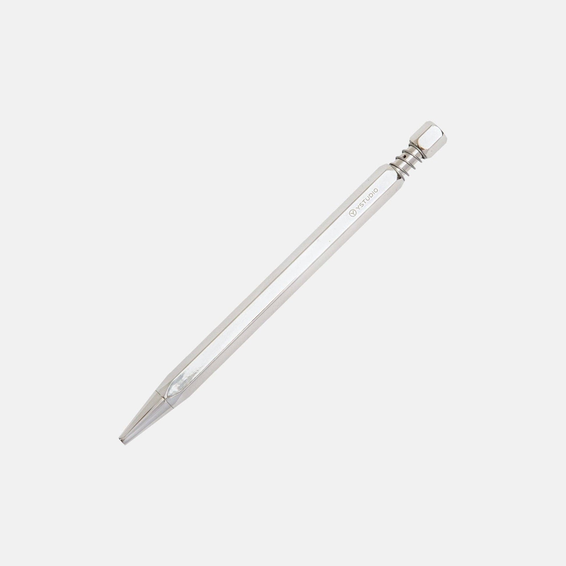 Die ENTREPÔT YSTUDIO Klassischer Drehkugelschreiber Feder in glänzendem Silber zeichnet sich durch einen schlanken sechseckigen Metallschaft und einen strukturierten Druckknopf aus, der elegant auf einem schlichten weißen Hintergrund steht.