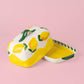 Die handgefertigte Keramik-Butterdose „Limone“ von Alfar Tierra Cocida in Gelb und Weiß präsentiert sich vor einem pinkfarbenen Hintergrund. Der Deckel, kunstvoll mit leuchtenden Zitronen und grünen Blättern verziert, hebt sich leicht von dem gelb-weißen Untergrund ab und unterstreicht stilvoll den mediterranen Charme dieses einzigartigen Tischaccessoires.