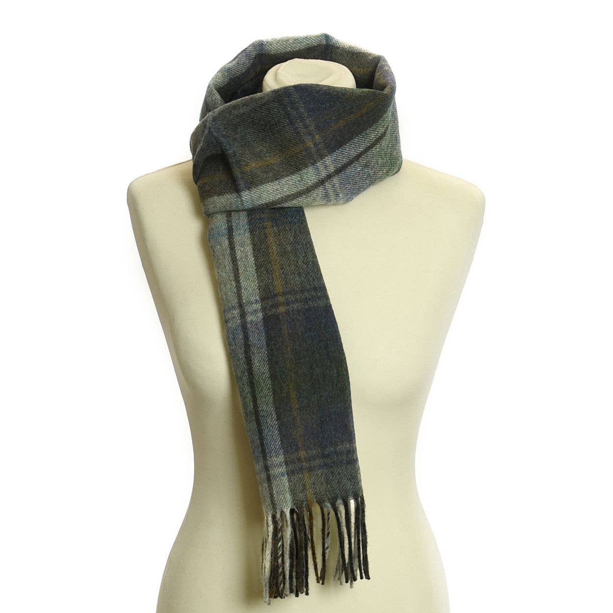 Ein Lammwoll-Landkaro-Schal von Tweedmill Textiles in Westray ist um den Hals einer cremefarbenen Schaufensterpuppe drapiert und zeigt weiche britische Lammwolle in grünem, blauem und grauem Karo mit Fransen.