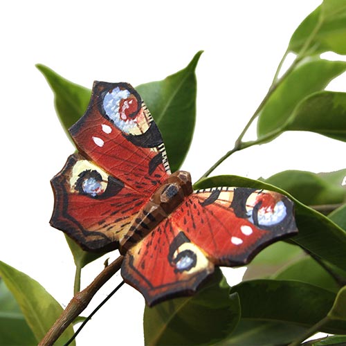 Der Wildlife Garden | 'Schmetterling Tagpfauenauge' Magnet aus handgeschnitztem Holz zeigt rote Flügel mit augenähnlichen Mustern, die auf einem grünen Zweig hocken - ein auffälliger Akzent für jede Wildlife Garden-Ausstellung.