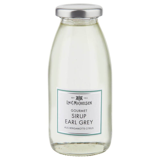 Eine klare Glasflasche mit Metallverschluss, gefüllt mit L.W.C. Michelsen | Gourmet-Sirup Earl Grey, 250 ml. Auf dem Etikett sind „Sirup Earl Grey“ und „aus Bergamotte-Zitrusfrüchten“ hervorgehoben, das Design ist schlicht und in Weiß und Blaugrün gehalten.