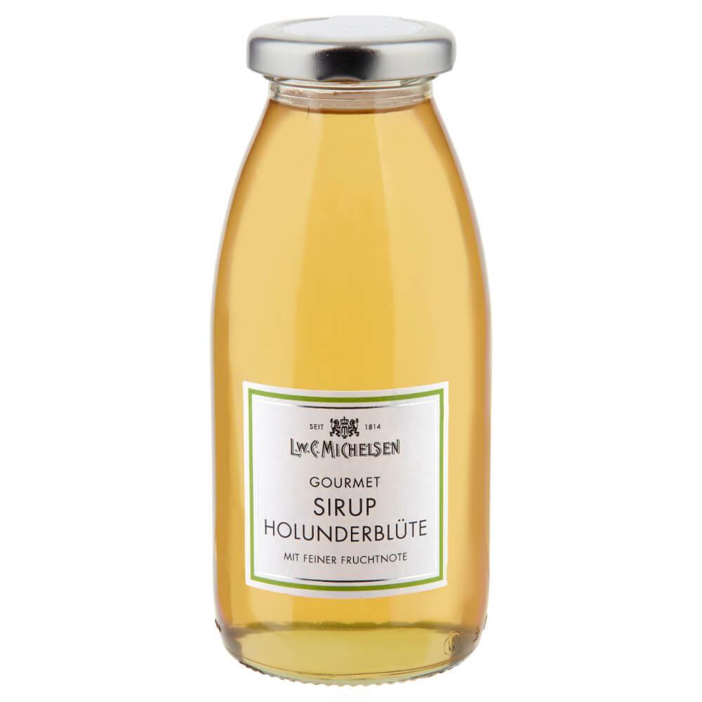 Eine durchsichtige Glasflasche mit silbernem Verschluss, gefüllt mit einer hellgelben Flüssigkeit. Auf dem Etikett steht „L.W.C. Michelsen | Gourmet-Sirup Holunderblüte 250 ml“, was darauf hinweist, dass es sich um einen hochwertigen Holunderblütensirup handelt, der von der renommierten Marke L.W.C. Michelsen für den Gourmet-Genuss hergestellt wurde.