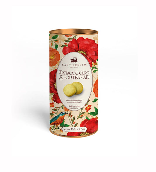 Auf dem Etikett der 130-g-Dose „The Lady Joseph | Butterkekse mit Pistaziencreme“ sind rote Mohnblumen, grüne Blätter, ein bunter Vogel und zwei Butterkekse mit Pistaziencreme abgebildet. Feines Gebäck für Genießer.