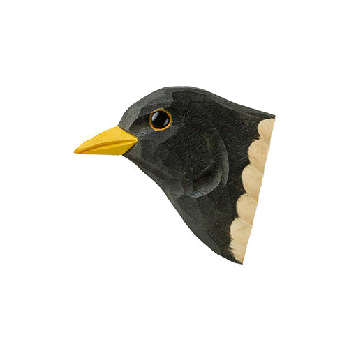 The Wildlife Garden | 'Amsel' Magnet aus handgeschnitztem Holz zeigt eine Amsel mit gelbem Schnabel, schwarzen Federn, weißem Halsfleck und glänzendem schwarzem Auge, kunstvoll geschnitzt und bemalt auf weißem Hintergrund.