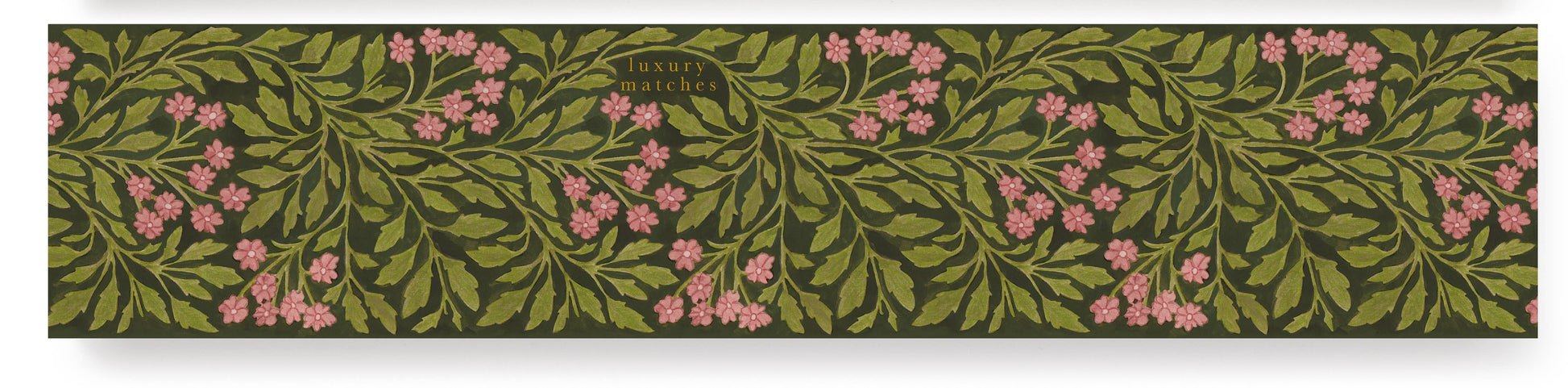 Die Archivist | 'Grüne Flora' Lange Streichhölzer von Archivist Gallery kommen in einer rechteckigen Schachtel mit grünen Blättern und rosafarbenen Blüten auf dunklem Hintergrund, mit "Luxus Streichhölzer" in kleiner goldener Schrift für einen eleganten Look.