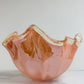 Die Murano Dream Dekoschale „Fazzoletto“ aus rosa Murano-Glas (H 20, Ø 22 cm) besticht durch ihren gewellten Rand und cremefarbene Akzente – ein elegantes Beispiel italienischer Glaskunst auf weißem Hintergrund.