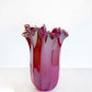 Eine große, glänzende, violette „Fazzoletto“-Vase (H 31, Ø 20 cm) von Murano Dream – handgefertigtes Murano-Glas mit gewellten Rändern –, präsentiert auf einer hellen Unterlage vor einem schlichten weißen Hintergrund.