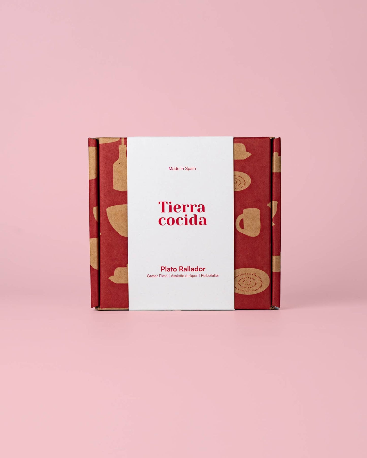 Auf einem rosa Hintergrund steht eine blaue, traditionell handbemalte kleine Keramik-Knoblauchreibe der Marke Alfar Tierra Cocida mit dem Namen „Nerja“. Auf der Verpackung sind der Markenname Alfar Tierra Cocida sowie Etiketten mit spanischen Texten zu sehen.