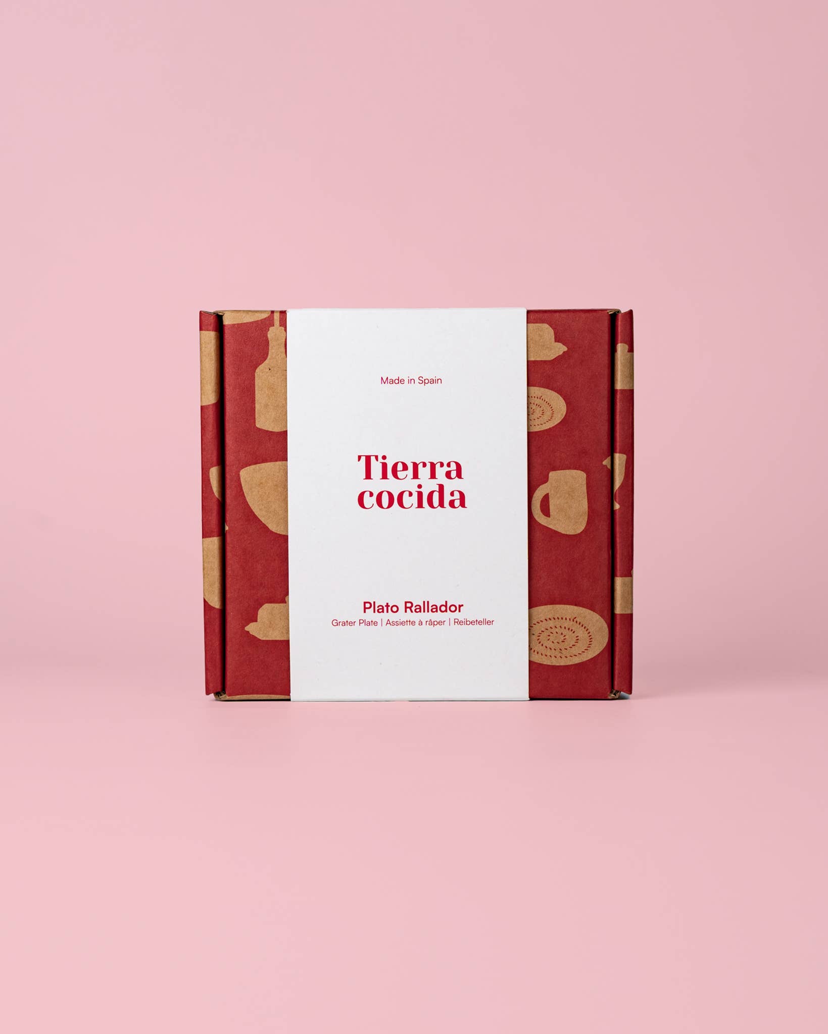Auf einem rosa Hintergrund steht eine blaue, traditionell handbemalte kleine Keramik-Knoblauchreibe der Marke Alfar Tierra Cocida mit dem Namen „Nerja“. Auf der Verpackung sind der Markenname Alfar Tierra Cocida sowie Etiketten mit spanischen Texten zu sehen.