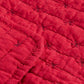 Die Nahaufnahme der IB Laursen Quilt Decke rot mit Kreuzstich zeigt den roten Steppstoff mit Gitter- und Kreuzstichdetails sowie eine gefaltete Kante, die den typischen Ib Laursen-Stil widerspiegelt.