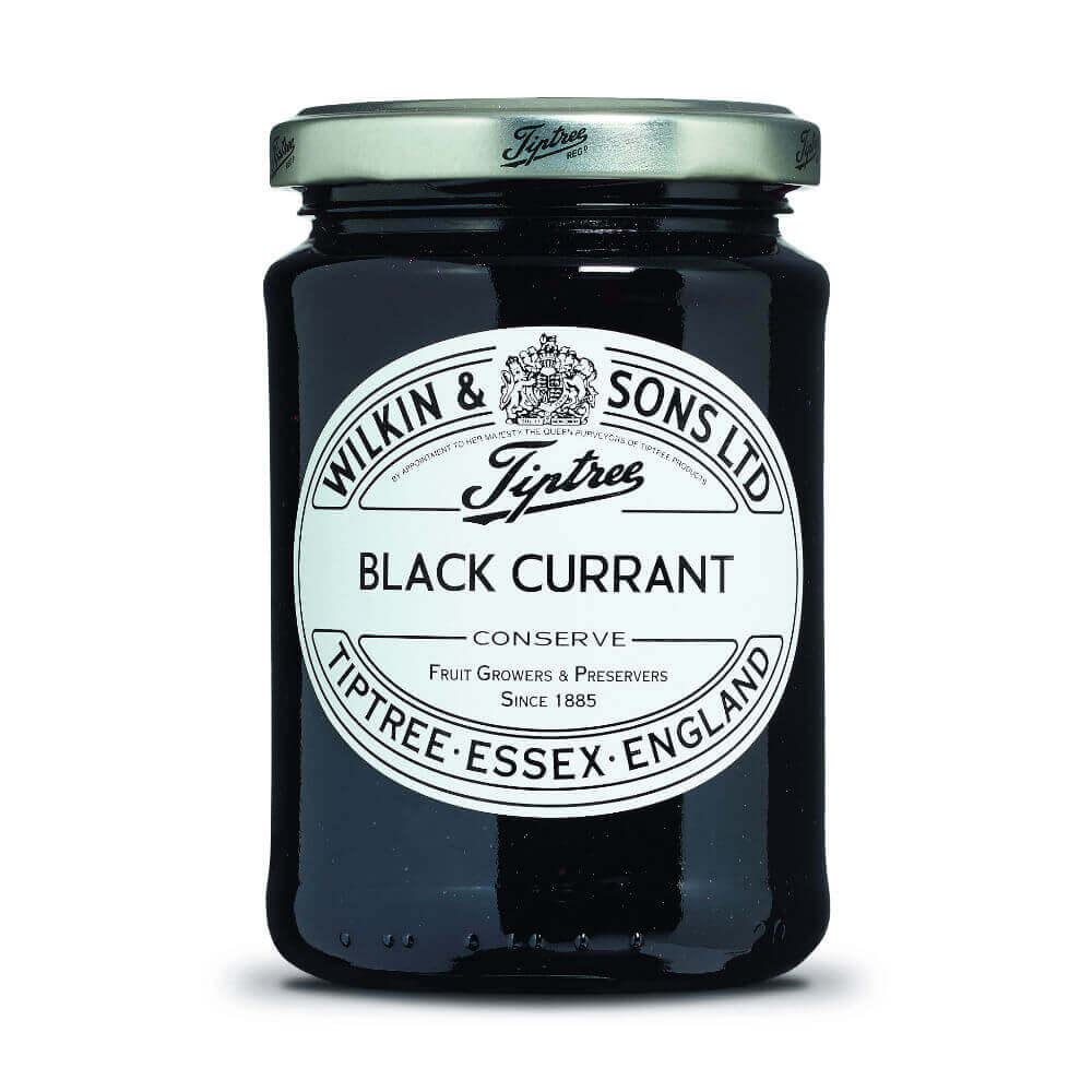 Ein 340-g-Glas der Marke Wilkin & Sons Tiptree mit Schwarze-Johannisbeer-Konfitüre und silbernem Deckel, versehen mit einem weißen Etikett mit schwarzer Aufschrift: „Tiptree Black Currant Conserve, Tiptree, Essex, England.“.