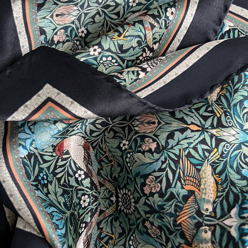 Nahaufnahme des Koustrupco | Seidenschal Morris Bird 50 x 50 cm, mit aufwändigen, von William Morris inspirierten botanischen und Vogelmustern in Grün, Blau und Schwarz auf luxuriöser Seide.