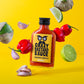 Eine 100-ml-Flasche Crazy Bastard Sauce Habanero & Tomatillo scharfe Soße mit frischen Tomatillos, Habaneros, Knoblauch und Limette auf gelbem Grund - eine kühne Soße für Fans von scharfen Aromen.