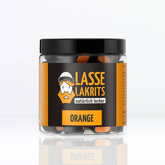 Ein durchsichtiges Glas mit der Aufschrift LASSE LAKRITS | Dose Lakritz Orange, gefüllt mit orangefarbener und schwarzer Fruchtlakritze, zeigt ein Cartoon-Gesicht mit Wintermütze. Diese LASSE LAKRITS Leckerei ist frei von Palmöl und steht auf einem weißen Hintergrund.