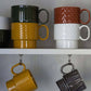 Zwei gelbe Tassen aus dem Set Kaffeebecher Gelb, 2-teilig der Sagaform GmbH hängen an ihren Henkeln und zeigen skandinavisches Design.
