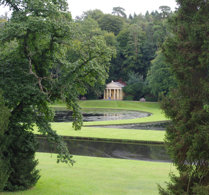 Im Yorkshire Garten erhebt sich hinter einem geschwungenen Teich und gepflegten Rasenflächen ein neoklassizistischer Tempel, eingerahmt von Bäumen, für Di., 16.2.2027 | 14.30 – 15.30 Uhr AFTERNOON TEA – Yorkshires vielfältige Gartenpracht.
