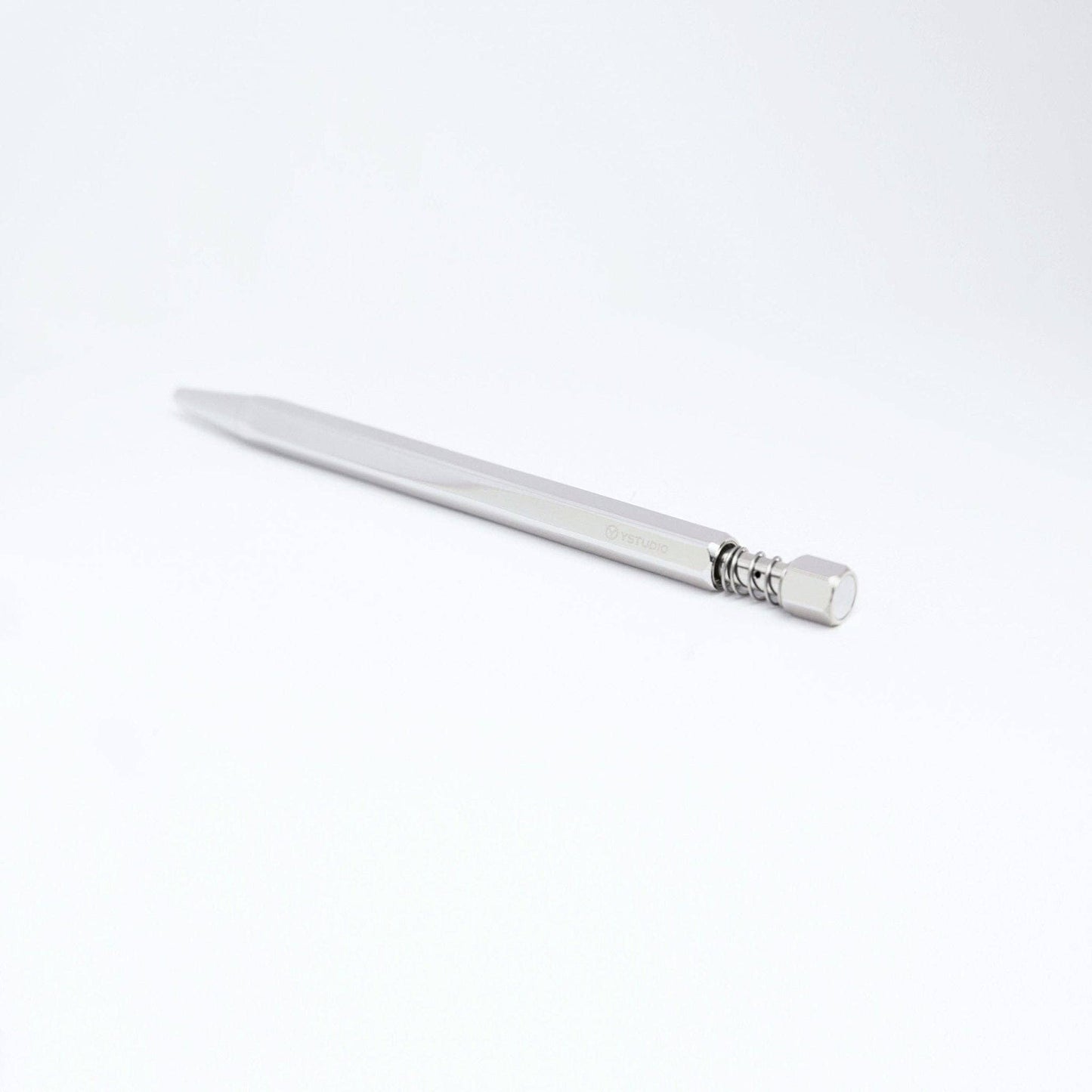 A YSTUDIO Klassischer Drehkugelschreiber Feder (Glänzendes Silber) von ENTREPÔT liegt diagonal auf weißem Untergrund, wobei Radiergummi und Metallclip zur Kamera zeigen.