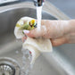 Eine Hand spült das More Joy Home | 'Zitrone' Biologisch abbaubares Schwammtuch unter fließendem Wasser in einer Küchenspüle ab - plätschernd und abtropfend für eine abfallfreie, umweltfreundliche Reinigung mit More Joy Home.