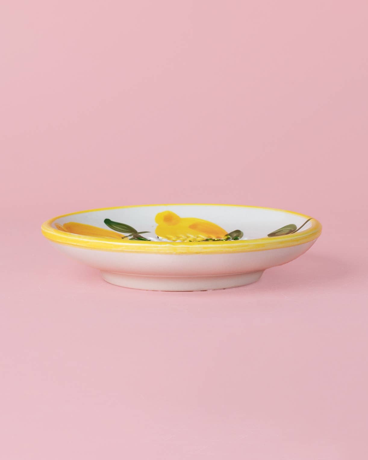 Die Alfar Tierra Cocida 'Limone' Keramik Knoblauchreibe (12,5 x 12,5 x 2,5 cm) zeigt ein handbemaltes Zitronenmotiv mit gelbem Rand auf zartrosa Hintergrund.