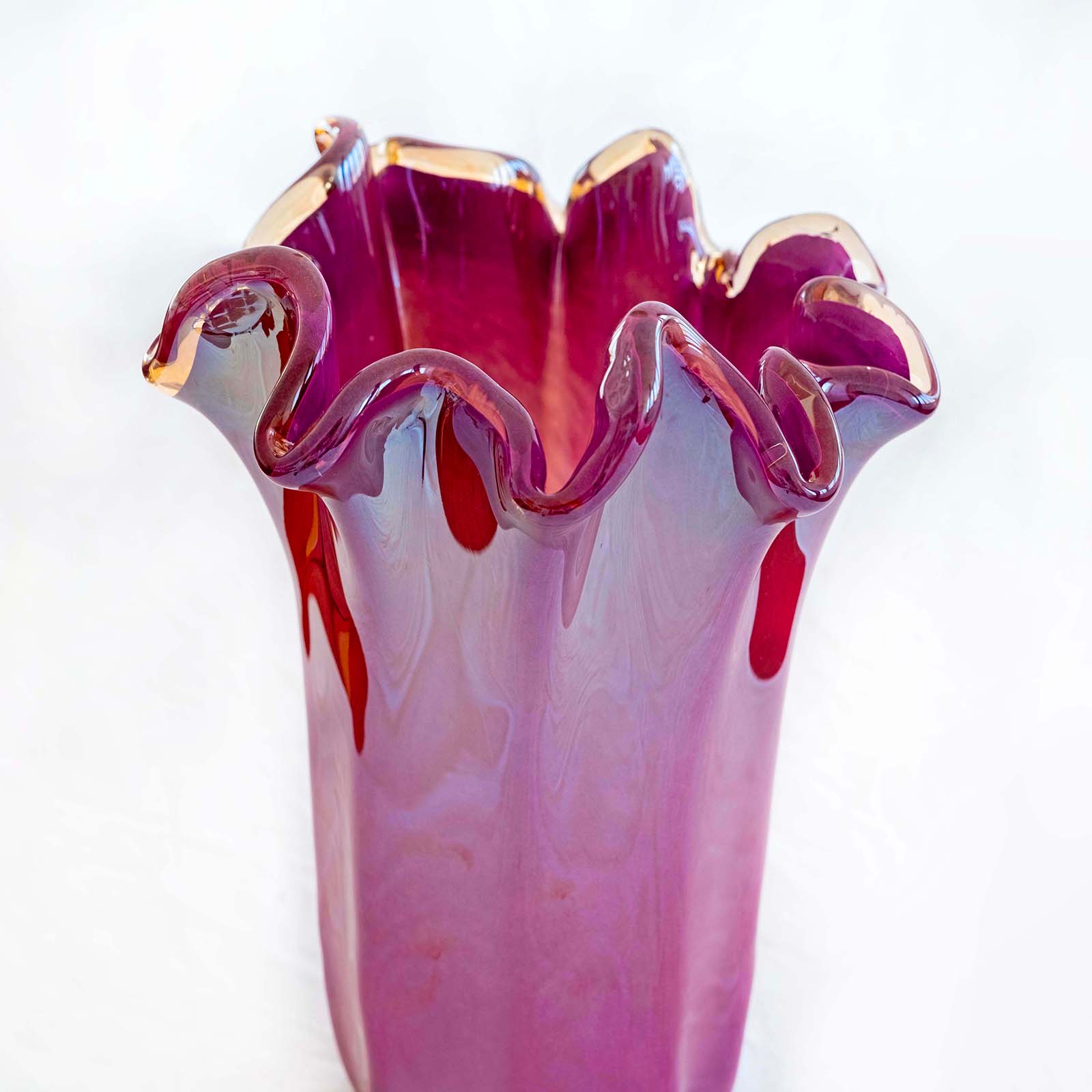 Die „Murano Dream“ – eine große violette „Fazzoletto“-Vase aus Murano-Glas (H 31, Ø 20 cm) – besticht durch handgefertigte Glaskunst mit einer wellenförmigen Öffnung in Rosa und Violett vor weißem Hintergrund.