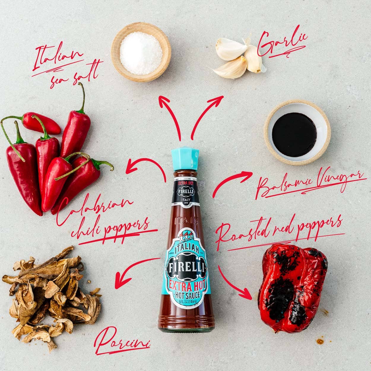 Eine Flasche Firelli | Extra scharfe italienische Sauce 148 ml ist umgeben von italienischem Meersalz, Knoblauch, Balsamico-Essig, geröstetem roten Pfeffer, Steinpilzen und kalabrischen Chilischoten - ideal für Grillfleisch.