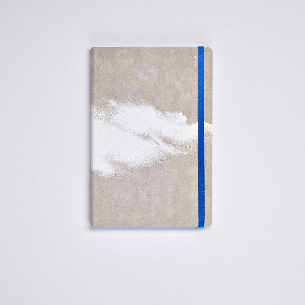 Ein geschlossenes nuuna | „Cloud Blue“-Inspirationsbuch in Größe M von nuuna, mit einem grau-weißen, strukturierten Einband, einem blauen Gummiband am rechten Rand und abgerundeten Ecken, abgebildet auf einem schlichten weißen Hintergrund.