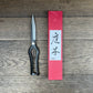 Ein Paar Niwaki 'Sentei Topiary Clippers' Buchsbaumschere mit Schlaufengriffen ruht neben einer hohen roten Schachtel mit japanischer Kalligrafie, beide von Niwaki, ausgestellt auf einer Holzfläche.