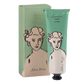 Eine grün-beigefarbene Tube Archivist | 'Aloe Vera' Handcreme von Archivist Gallery, die ein illustriertes Frauengesicht zeigt, steht neben der passenden Schachtel mit ähnlichem Bild und Text.