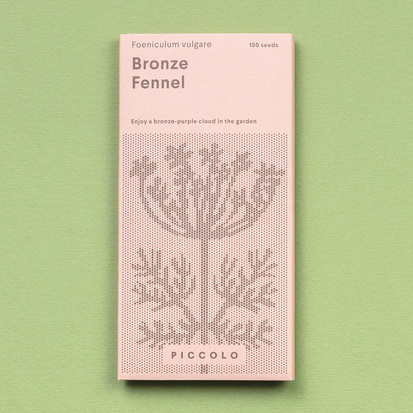 Eine rosafarbene Piccolo Seeds-Packung mit der Aufschrift "Fenchelbronze" zeigt eine gepunktete Illustration der Gewürzpflanze, listet 150 Fenchelsamen auf und steht auf einem hellgrünen Hintergrund.