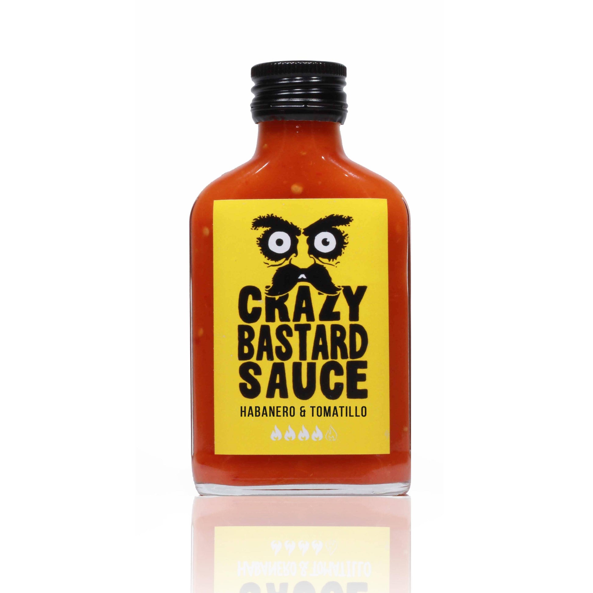Eine 100-ml-Glasflasche mit Crazy Bastard Sauce, Habanero & Tomatillo scharfe Soße, mit einem gelben Etikett mit fetter schwarzer Schrift und einem Cartoon-Gesicht mit großen Augen und Schnurrbart. Die Soße darin ist leuchtend rot.