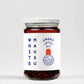 Ein 100-ml-Glas von White Mausu | Rauchiges Chiliöl von White Mausu Ltd. mit weißem Deckel. Das Etikett zeigt "WHITE MAUSU" vertikal auf der linken Seite und "SMOKY Chiliöl" neben einem orangefarbenen Oval und einer minimalistischen Mausillustration auf der rechten Seite.