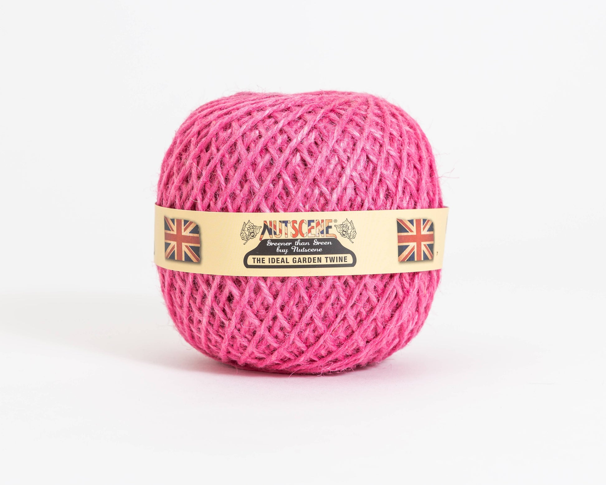 Auf einem schlichten weißen Hintergrund liegt ein Knäuel leuchtend pinkfarbenes „Nutscene | Heritage Jutegarn in Pink“ (130 m) von Nutscene Twines Ltd. Auf dem beigen Etikett ist der Name „Nutscene“ zu sehen, flankiert von zwei Union-Jack-Flaggen, eine auf jeder Seite.