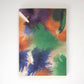 Das Papaya Paper Products | Notizheft A6 mit Aquarell/Watercolor-Motiv, FSC zertifiziert und mit blanko Seiten, zeigt bunte grüne, orange, lila und blaue Flecken auf dem Cover und liegt geschlossen auf weißem Hintergrund.