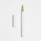 Der ENTREPÔT YSTUDIO | Harz-Rollerball-Stift (Weiß), mit Acryl- und Messingkörper sowie goldener Spitze, liegt auf einer weißen Fläche neben der passenden Kappe.