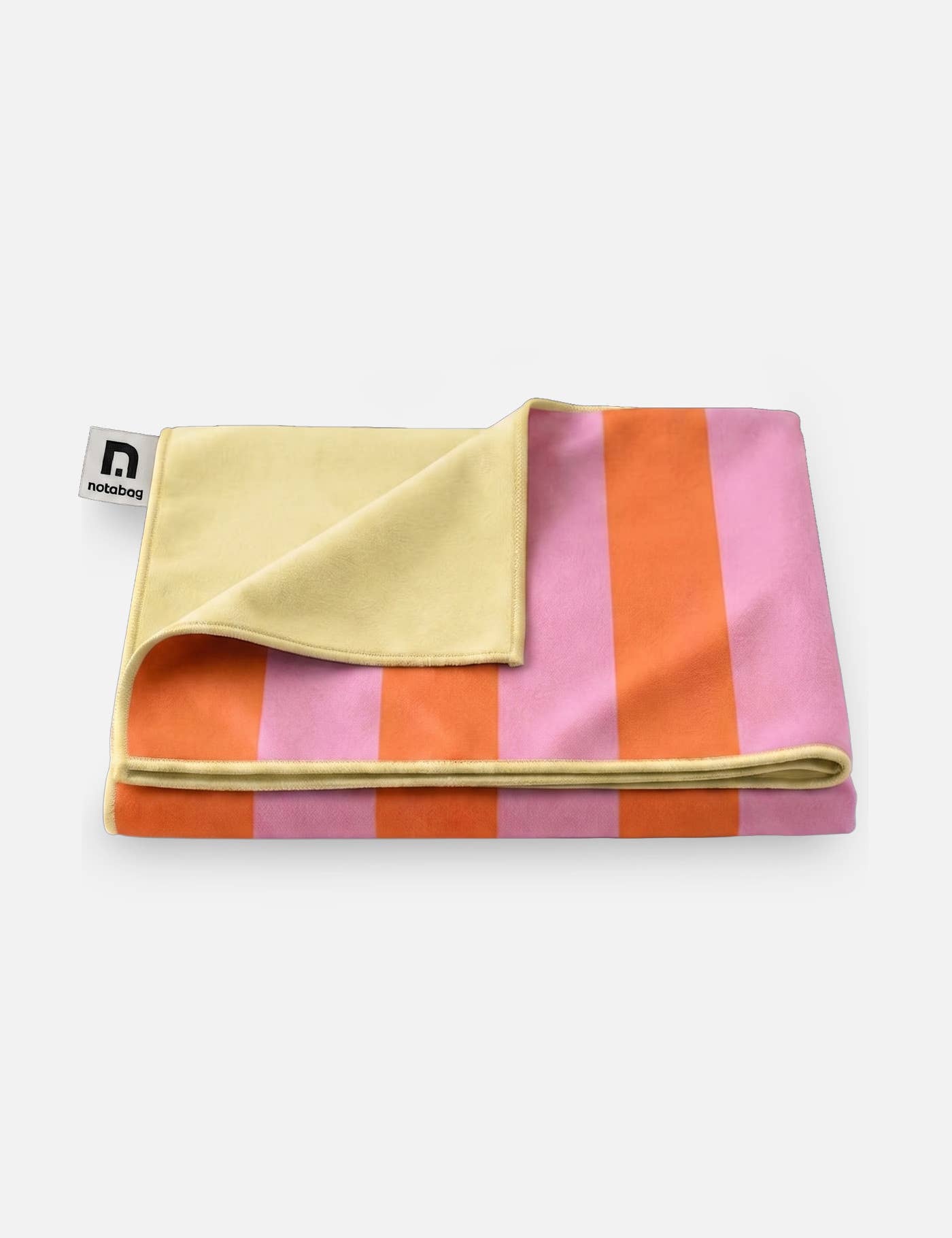 Das Notabag | Handtuch orange & rosa gestreift (78 × 160 cm) von Notabag ist hier gefaltet abgebildet und zeigt breite rosa und orangefarbene Streifen sowie eine zartgelbe Rückseite. Es besteht aus recyceltem Polyester und ist an einer Ecke mit einem weißen Etikett mit schwarzem Logo versehen.
