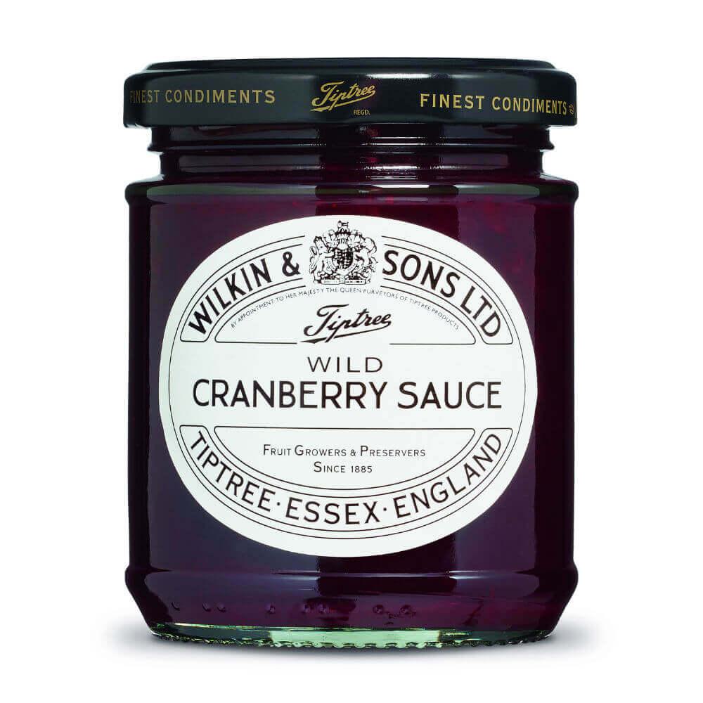 Ein Glas „Wilkin & Sons Tiptree Wild Cranberry Sauce“ (210 g), eine erlesene englische Fruchtsauce, mit einem weißen Etikett und schwarzer Schrift, auf dem der Produktname und die Herkunft angegeben sind: Tiptree, Essex, England. Die tiefrote Sauce im Glas spiegelt ihren intensiven Cranberry-Geschmack wider.